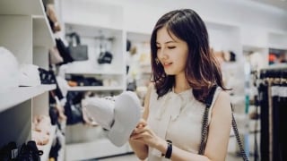 Women looking at a pair of white shoes in a store