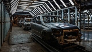 Half built cars lined up in manufacturing factory